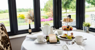 Guests enjoying Bustronome’s afternoon tea on a double-decker bus with panoramic London views.